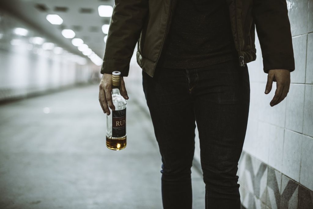 Alcoholic Homeless Holding Liquor Bottle
