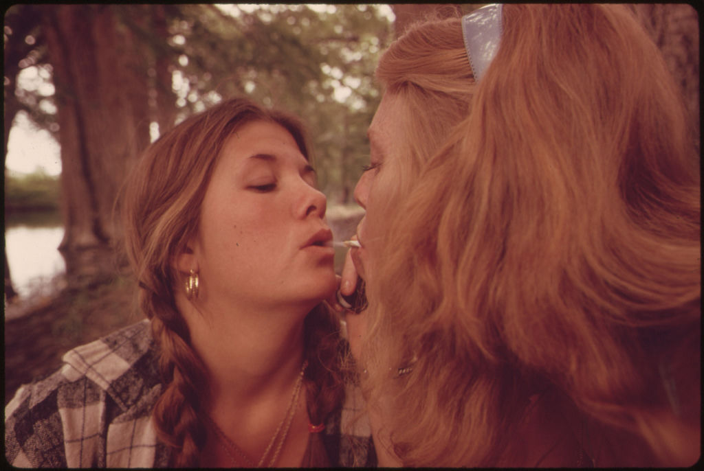 Two Girls Smoking Pot During an Outing in Cedar Woods near Leakey, Texas.