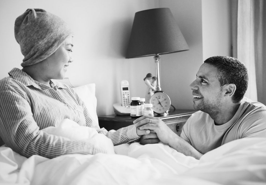 sick woman in bed with partner