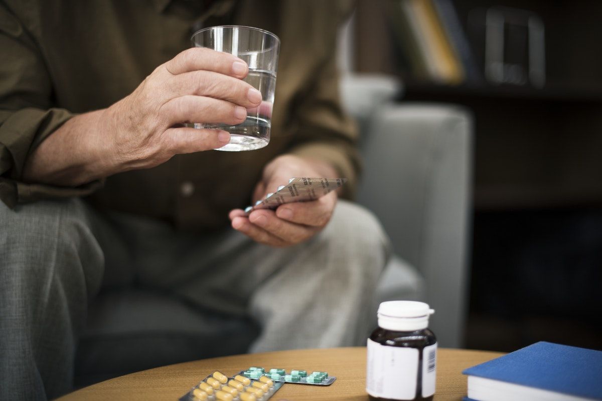 elderly person taking THC pills / CBD capsules